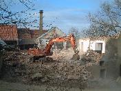 Schwere Baumaschinen brechen das Mauerwerk ein